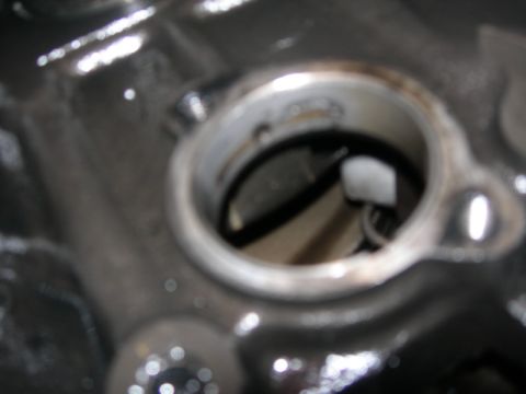 1984 Ford Bronco - A detailed view of an engine part, possibly during a rebuild, with a circular opening revealing internal mechanisms.