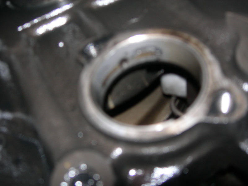 Close-up of an engine component with a circular opening and visible internal parts