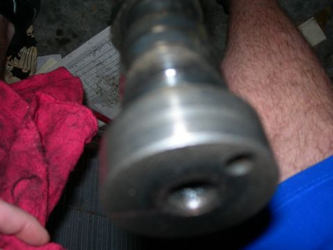 1984 Ford Bronco - A close-up shot of a metal automotive part, likely from an engine, with a red cloth and some papers visible.