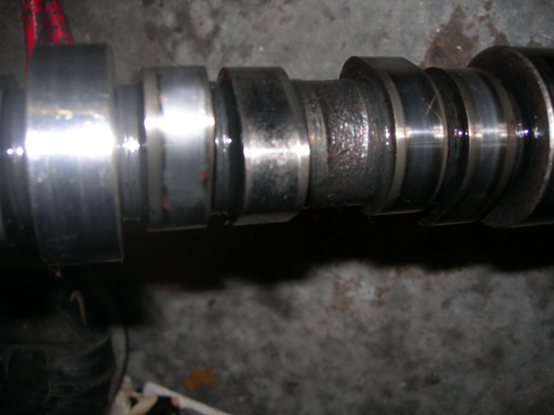 Close-up of a camshaft with multiple lobes and bearing surfaces