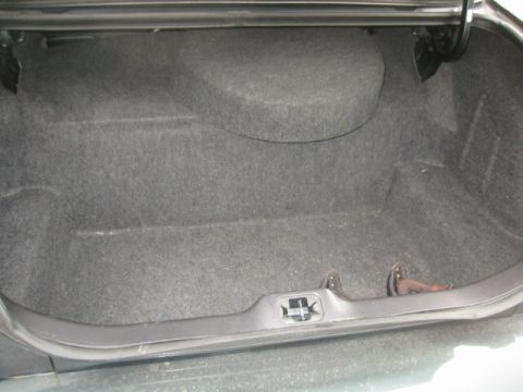 1998 Ford Crown Victoria - The interior of a 1998 Ford Crown Victoria's trunk is shown, grey carpeting and a spare tire cover.