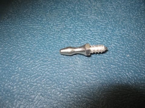 1968 Shelby GT500 - A close-up view of a single metal screw with a pointed tip and threaded shaft rests on a textured blue surface.