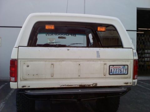 1986 Ford Bronco - Rear view of a white 1986 Ford Bronco, showing its tailgate and license plate.