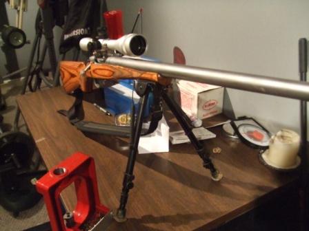 1996 Ford Bronco - Rifle with scope and bipod rests on a table, with reloading equipment nearby.