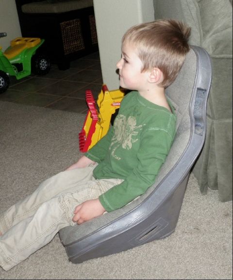 1994 Ford Bronco - A young boy sits in a gray car seat, with toys in the background.