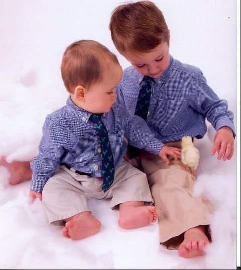 1994 Ford Bronco - A baby and an older boy, both dressed in button-down shirts and ties, interact with a small chick amidst a fluffy white background.