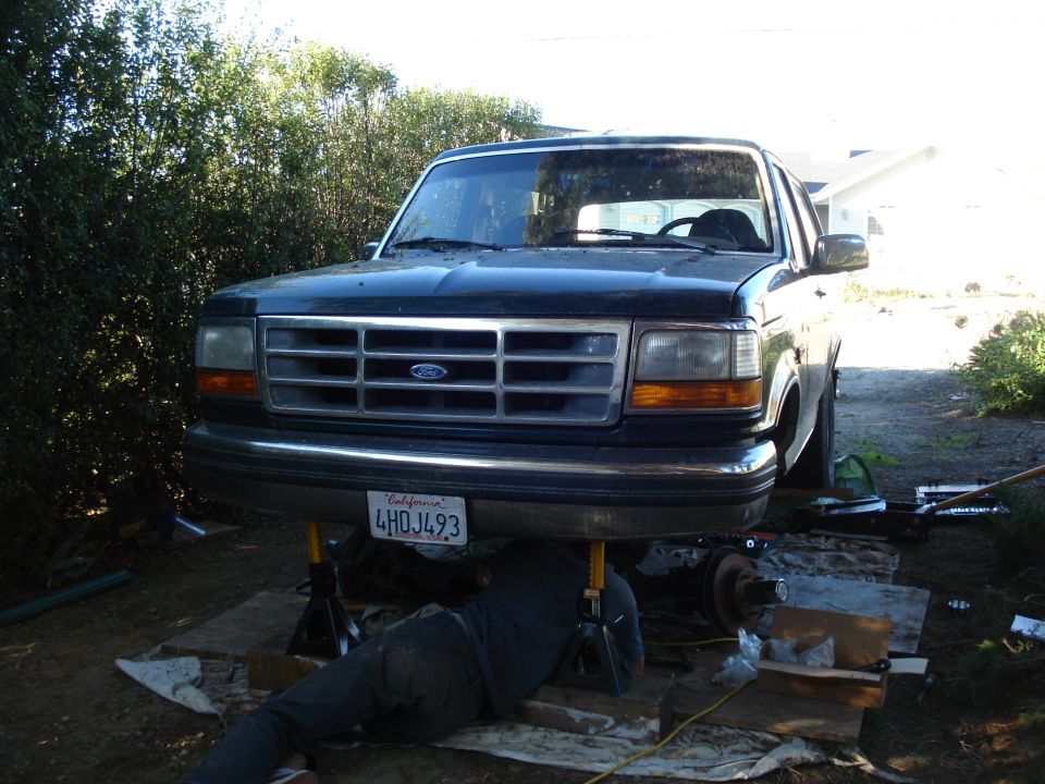 Front view of a 1993 Ford Bronco on jack stands, undergoing maintenance