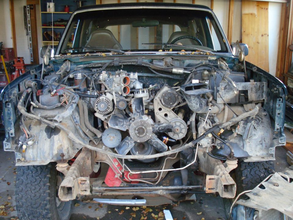 vehicle engine bay with front end removed, showing engine and components