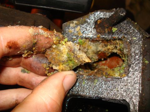 1993 Ford Bronco - A heavily corroded engine part shows significant buildup of green and yellow deposits, indicating potential internal damage.