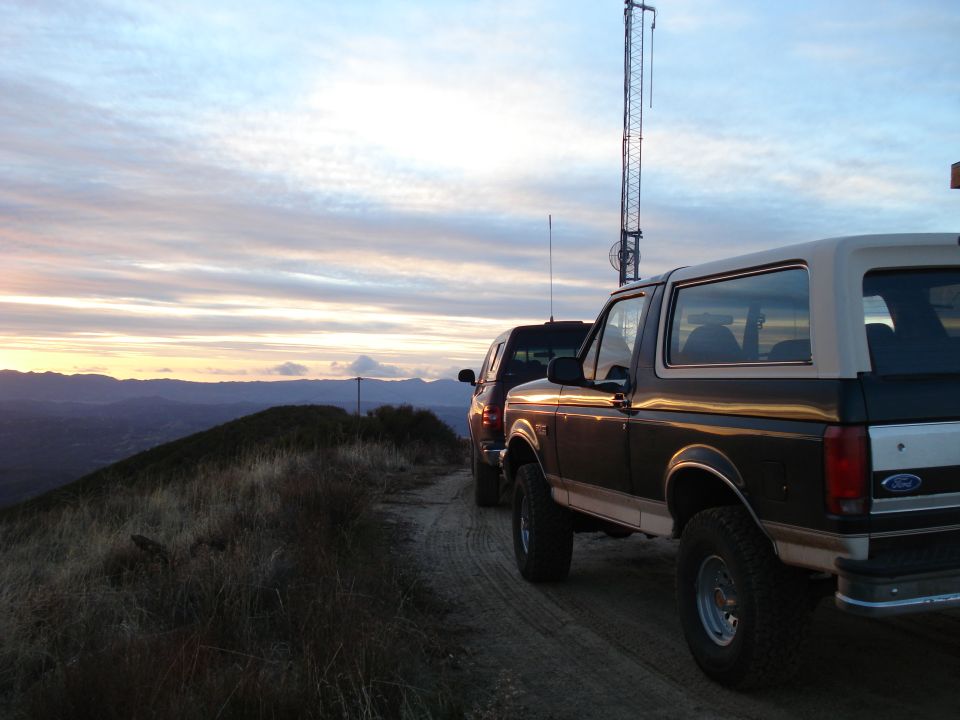 Brown and white 1993 Ford Bronco parked on a dirt road with another vehicle behind it