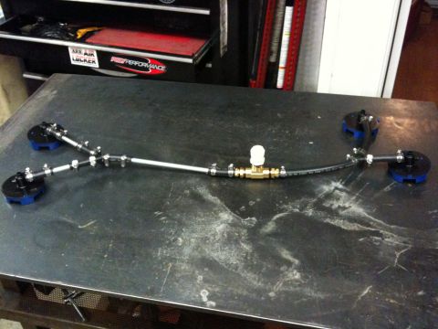 2009 Suzuki Samurai - A custom fuel line assembly with brass fittings and blue-capped ends is laid out on a workbench.