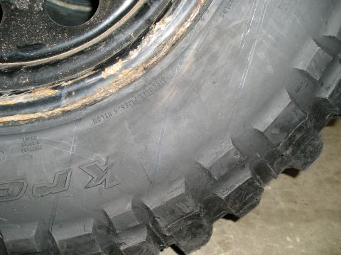 1986 Toyota Hilux - Close-up view of a worn tire and a rusty rim, showing tread detail.