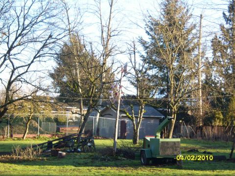 1989 Ford Bronco - A wood chipper sits in a grassy yard next to a shed and basketball hoop.