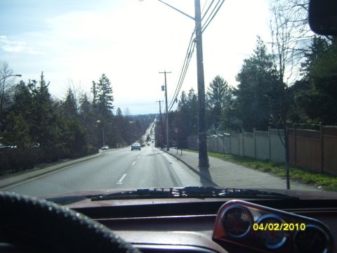 1989 Ford Bronco - View from inside a vehicle looking down a tree-lined road with other cars. The date 04/02/2010 is visible.