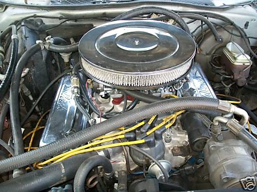 Chrome-topped V8 engine with round air cleaner in an engine bay