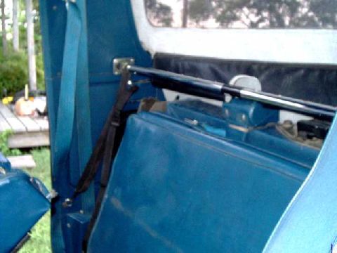 1984 Ford Bronco - metal support bar, goes across cab behind rear seat, inside the flaps of the softtop, secured by straps anchored to trim panels