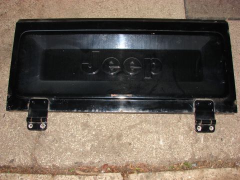 1979 Jeep CJ7 - This black tailgate features the embossed Jeep logo and hinges, likely from an older Jeep model.