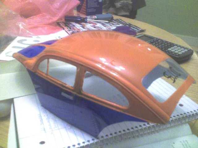 Orange and blue Volkswagen Beetle body shell, side view