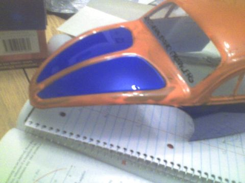 1989 Ford Bronco - Model car body with blue window inserts, placed on a notebook.