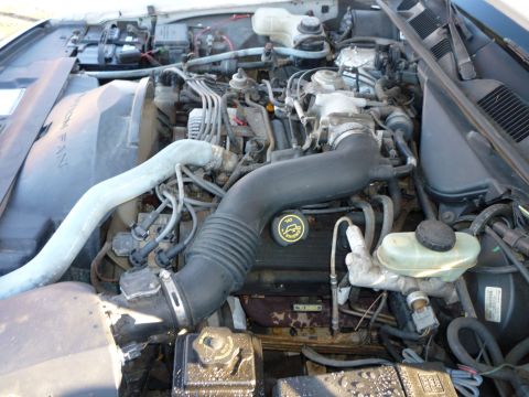 1997 Ford Crown Victoria - The engine bay of a vehicle is shown with various mechanical parts and wiring.