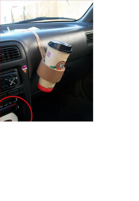 1996 Ford Bronco - A coffee cup is held in a brown fabric holder attached to the car's dashboard.