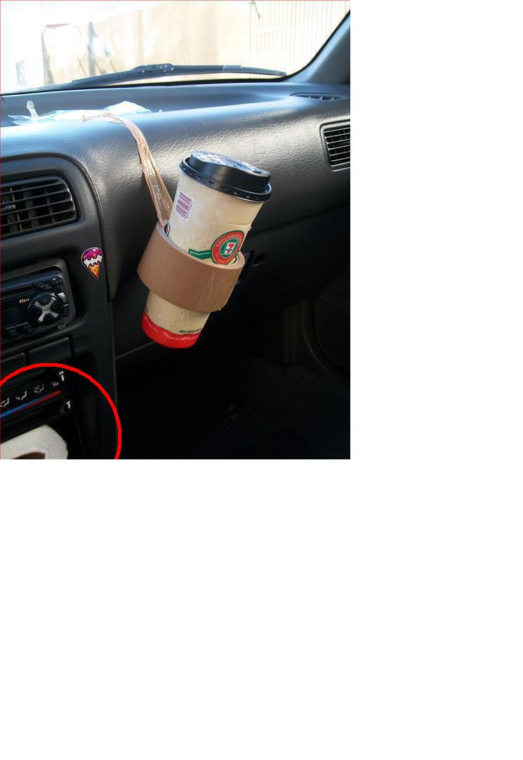 Car dashboard with a cup holder holding a coffee cup. Ice cream sticker on the left