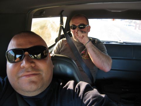 1986 Ford Bronco - Two men are inside a vehicle, with one taking a selfie and the other in the background.