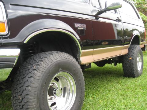 1994 Ford Bronco - Side view of a lifted 1994 Ford Bronco with 33-inch tires and two-tone paint.