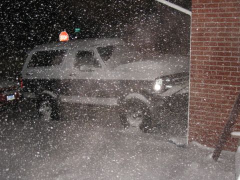 1994 Ford Bronco - Ford Bronco parked near a brick building during heavy snowfall.