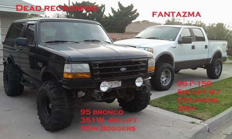 1995 Ford Bronco - This modified 1995 Ford Bronco features a 4-inch lift and 35-inch bogger tires, parked next to a white pickup truck.