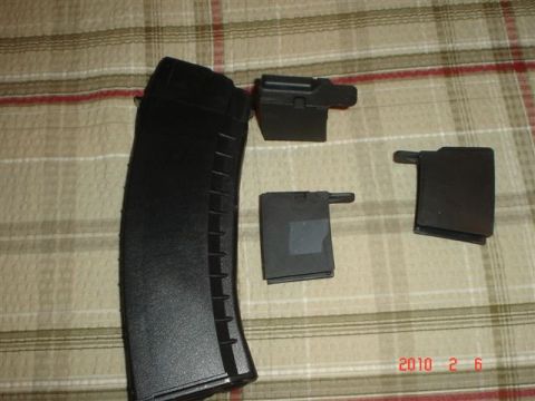 2000 Ford Crown Victoria - Several black gun magazines and parts are laid out on a plaid fabric surface.