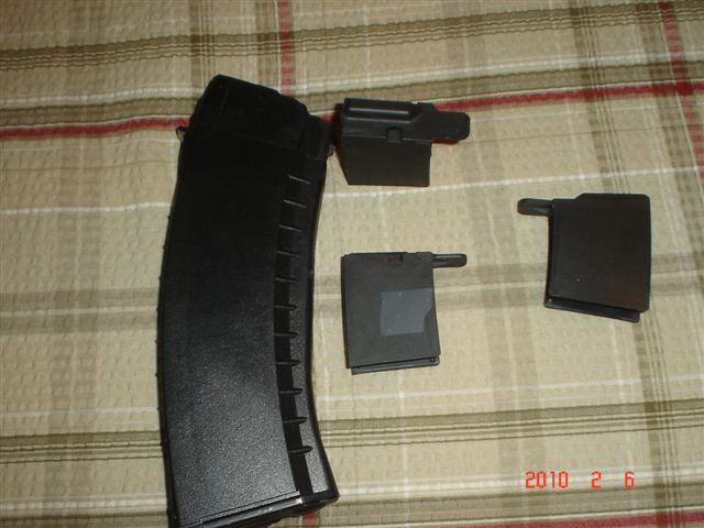 gun magazines and parts on a plaid surface