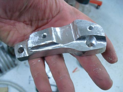 1996 Ford Bronco - A person holds a custom-machined aluminum part, likely a component for a larger assembly.