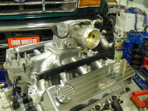1996 Ford Bronco - Engine parts are laid out in a garage, with a "Four Wheeler" plate in the background.
