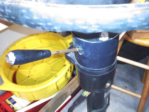 1977 Ford F-100 - Close-up of a vehicle's steering column and turn signal lever, with a yellow oil drain pan in the background.