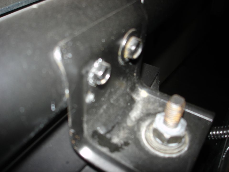 Close-up of bolts and metal bracket with Supermotors.net watermark