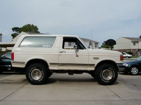 1990 Ford Bronco - Side profile of a white 1990 Ford Bronco, modified with a body lift and larger tires.