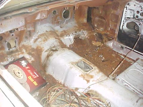 1970 Ford Mustang - The interior of this vehicle shows significant rust damage and a pile of electrical wires on the floor.