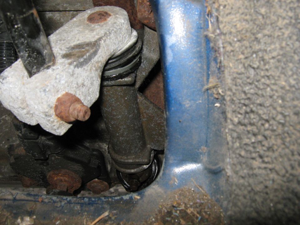 Close-up of a rusty suspension part with a rubber bushing