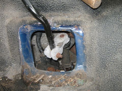 1996 Ford F-150 - Close-up of a vehicle's interior gear shifter mechanism, showing mechanical components and surrounding floor.