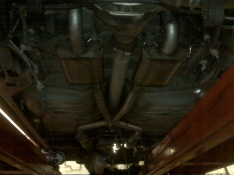 2001 Ford Crown Victoria - The underside of a 2001 Ford Crown Victoria reveals its dual exhaust system with mufflers and central pipe.