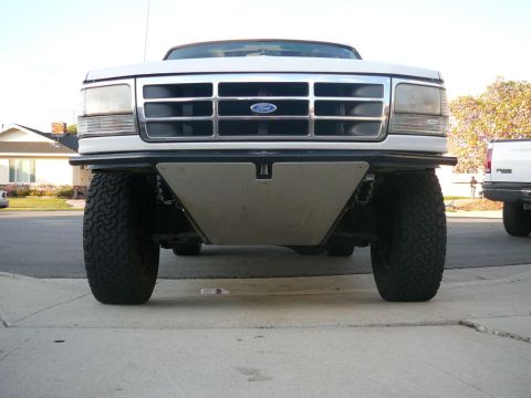 1988 Ford Bronco - Front view of a white Ford truck, likely a 1992-1997 model, a prominent aftermarket skid plate.
