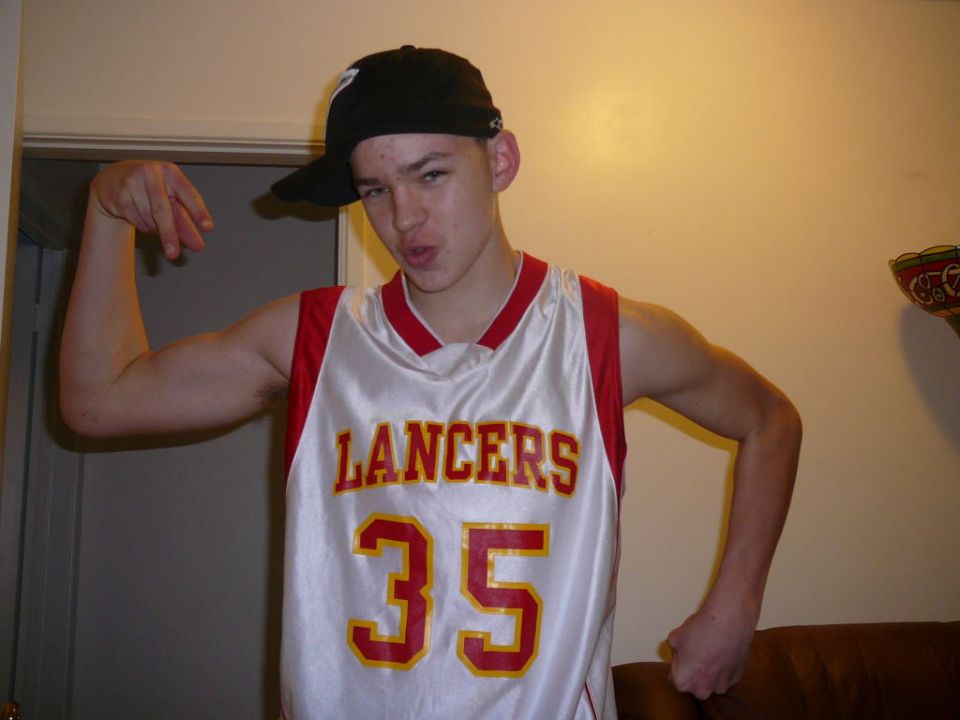 Teenager wearing a white and red 'Lancers 35' basketball jersey and a black baseball cap
