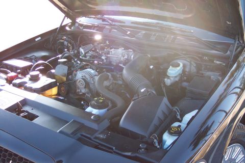2001 Ford Crown Victoria - The engine compartment of a 2001 Ford Crown Victoria is shown with the hood raised.