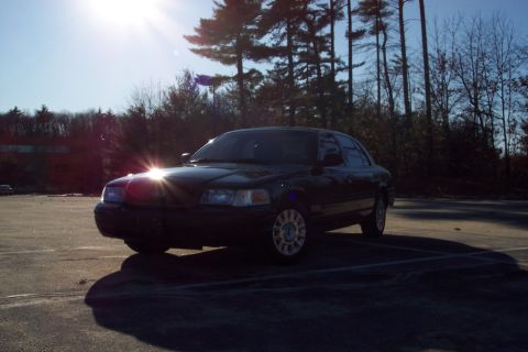 2001 Ford Crown Victoria - Front 3/4 view of a dark-colored 2001 Ford Crown Victoria in a parking lot.