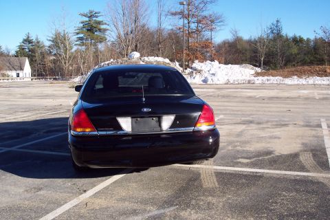 2001 Ford Crown Victoria - Rear view of a black 2001 Ford Crown Victoria parked in a snowy lot.