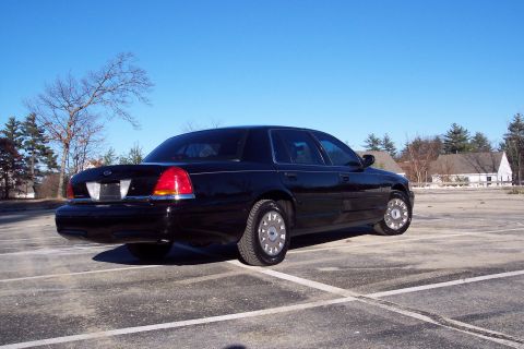 2001 Ford Crown Victoria - This black 2001 Ford Crown Victoria is shown from a three-quarter rear view in an outdoor parking lot.
