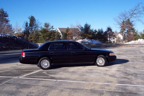 2001 Ford Crown Victoria - Side profile of a black 2001 Ford Crown Victoria parked in a lot on a clear day.
