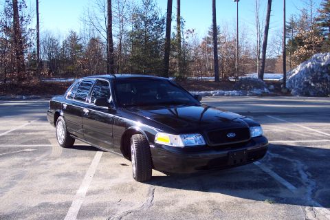 2001 Ford Crown Victoria - A black 2001 Ford Crown Victoria is parked in an outdoor lot on a sunny day.