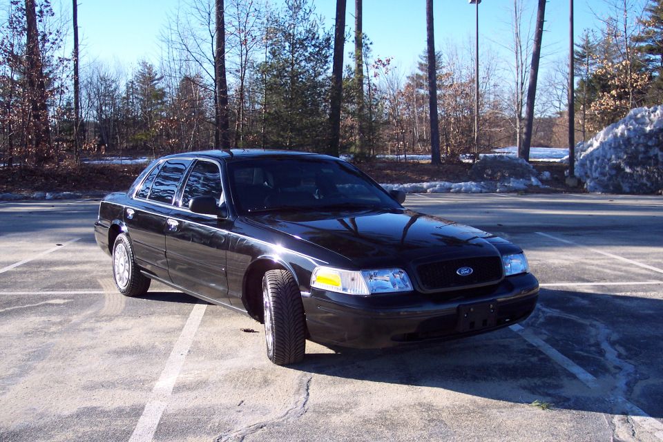 Black 2001 Ford Crown Victoria parked in a lot, front 3/4 view, clear sky